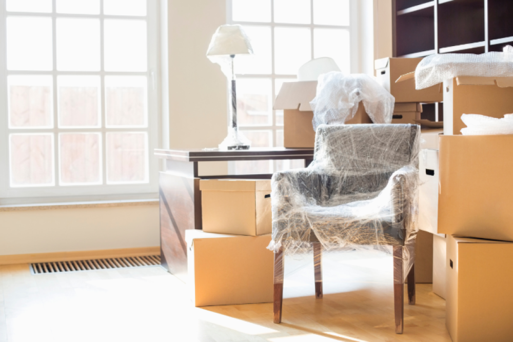 Packed moving boxes and wrapped furniture inside a home