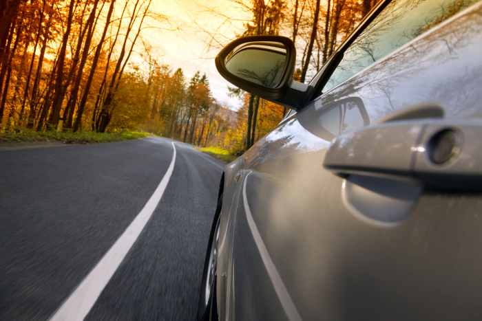 Car being driven on a rural road for long-distance transportation