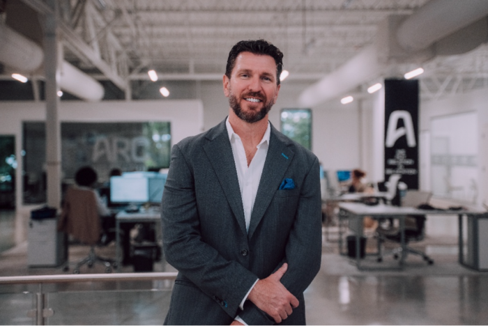 Bill Mulholland, founder of Agoyu, standing in a modern office